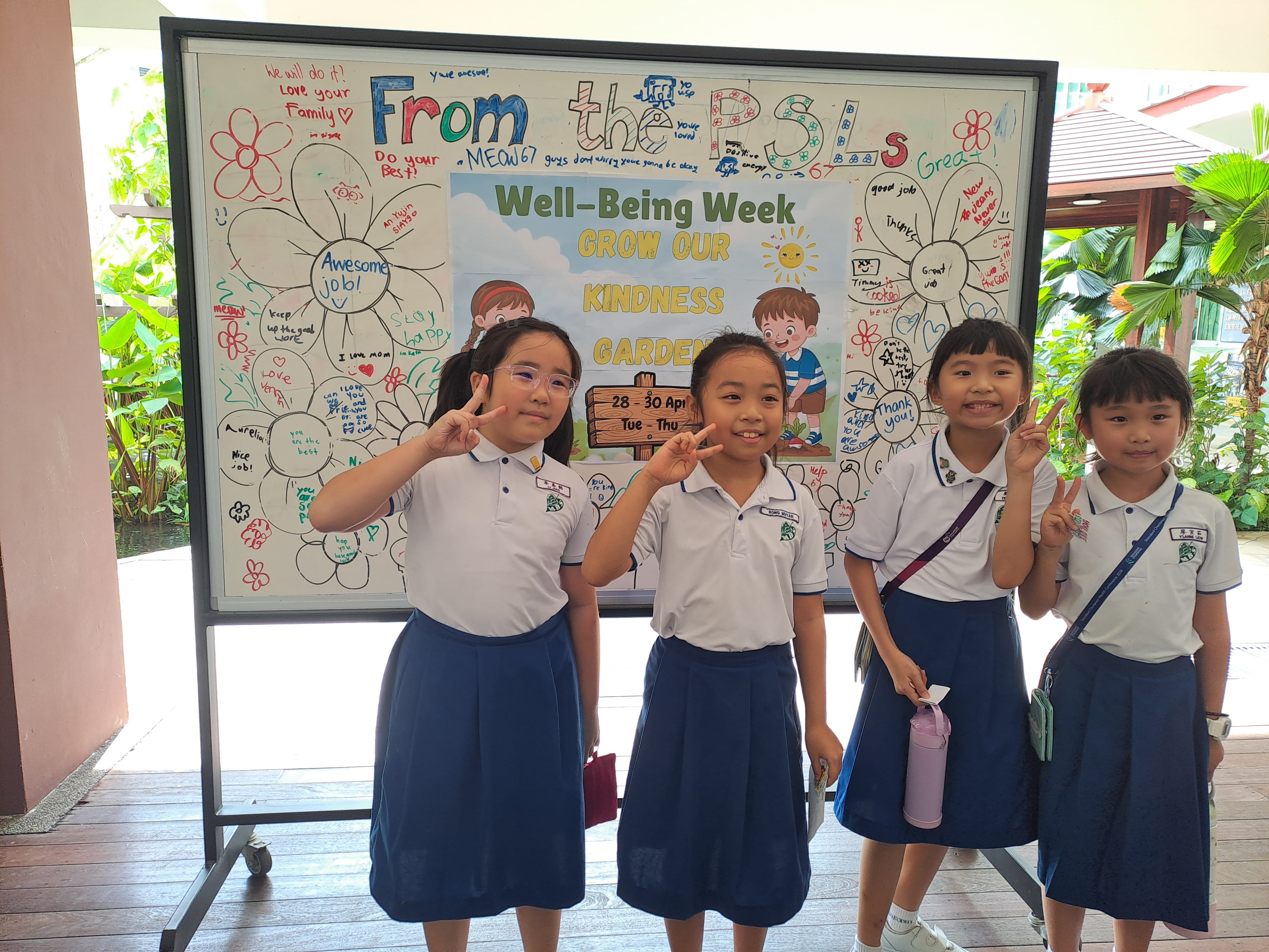 Pupils taking photo in front of pupils created colourful whiteboard with the theme ‘Well Being Week." 